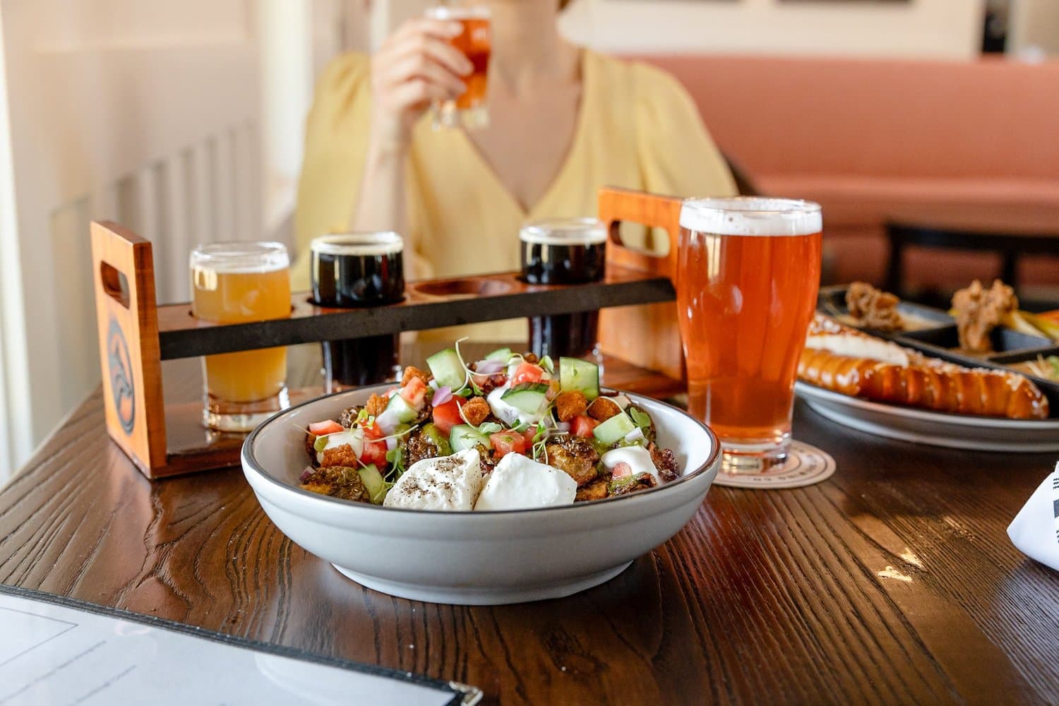 A salad, beer flight, and fresh pints on the table